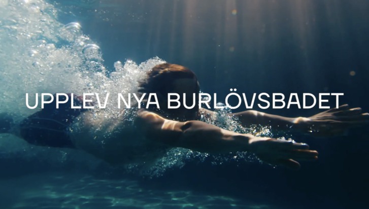 Bild av en simmare dyker och simmar under vatten i en pool. Texten "Upplev nya Burlövsbadet" syns på bilden."