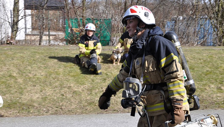 Personal från Räddningstjänst bär brandslang
